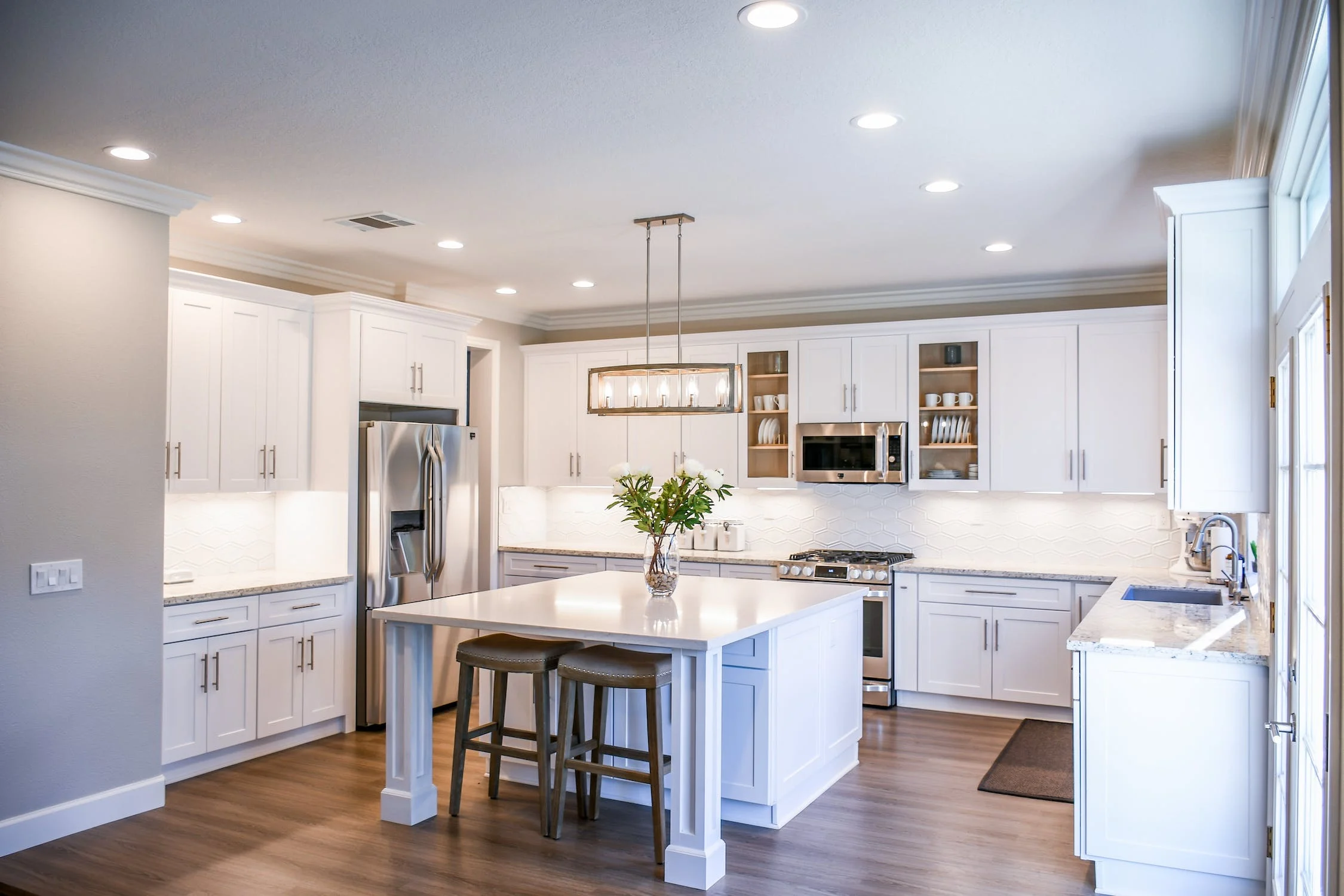 Renovated open-plan kitchen with white cabinetry and large island